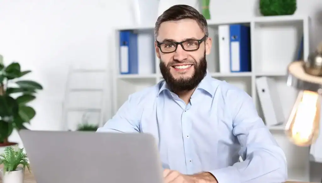 “Professional on a laptop in a modern office using Screamer Telecoms voice and collaboration tools for business calls and meetings.